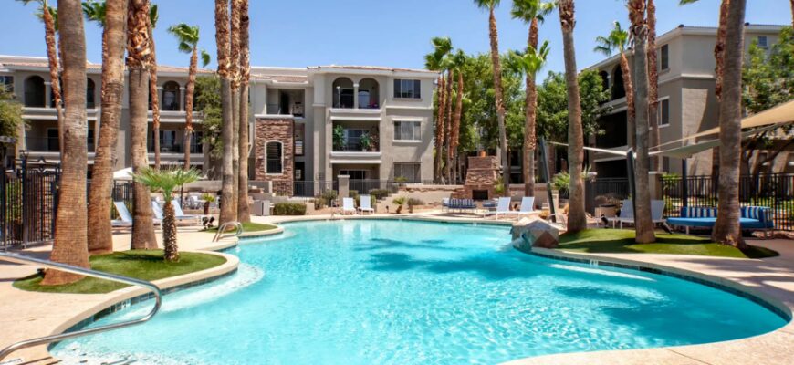 Outdoor pool area with surrounding palm trees and exterior view of the property building
